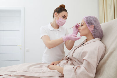 Female doctor examining patient at home