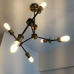 Low angle view of illuminated light bulb hanging from ceiling