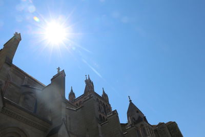 Low angle view of building against blue sky on sunny day