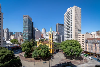 Buildings in city against clear sky