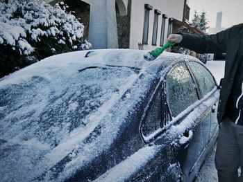 Man removing snow from car