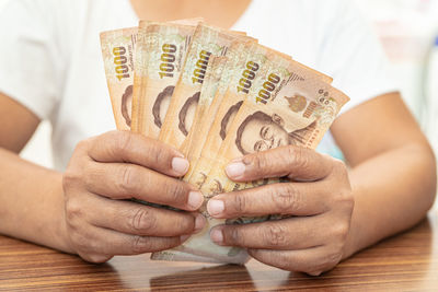 Midsection of woman holding paper currency