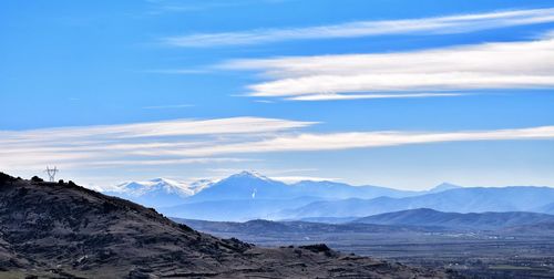 Scenic view of mountains against blue sky