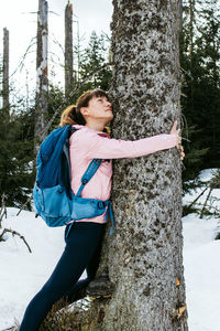 A girl in the spring forest hugs a tree trunk. the concept of protection and love for nature.