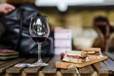 Snack and wineglass on wooden table at restaurant