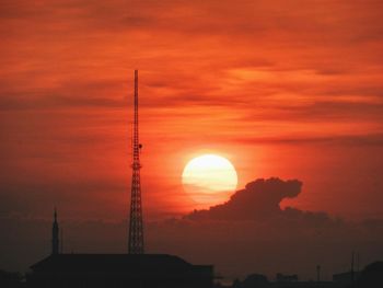 Silhouette tower against orange sky during sunset