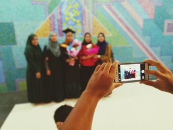 Midsection of woman photographing mobile phone