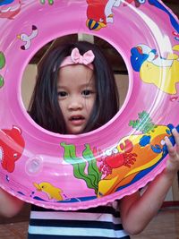 Portrait of cute girl holding inflatable raft