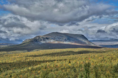 Scenic view of mountains against cloudy sky