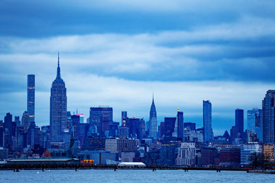 Modern buildings in city against cloudy sky