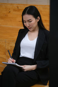 Beautiful young woman sitting with umbrella