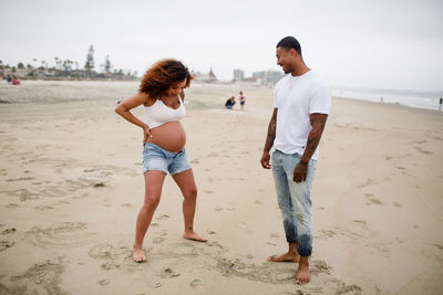 Mixed race couple goofing around on beach