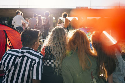 Rear view of people standing in a row