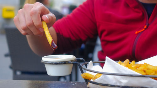 Close-up of man holding ice cream on table