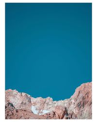 Low angle view of rock formation against clear blue sky