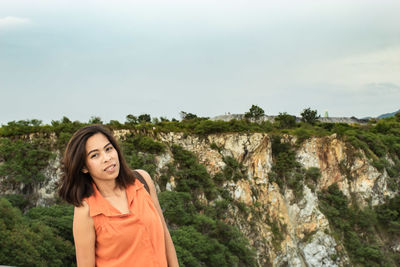 Portrait of woman standing against mountain