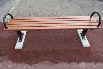 High angle view of wet empty bench in park