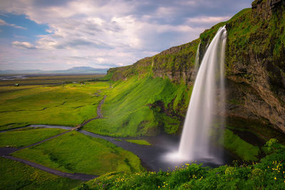 Scenic view of waterfall against sky