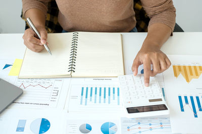 Midsection of business colleagues working on table