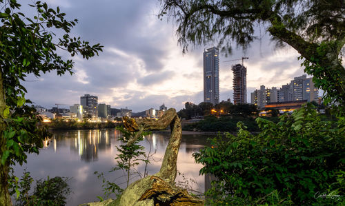 Scenic view of lake by buildings against sky