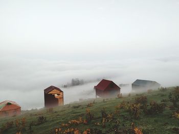 Houses on field against sky