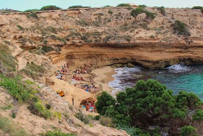 High angle view of people by rock formation at beach