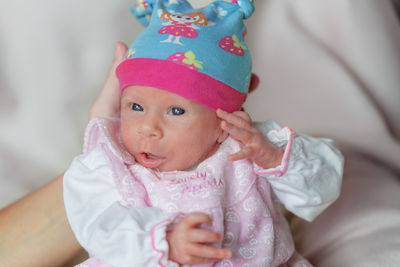 Portrait of cute baby girl on bed at home