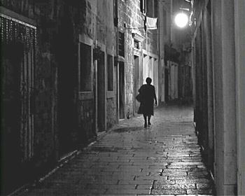 Full length rear view of woman walking in building