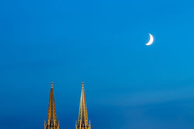 Low angle view of moon against clear blue sky