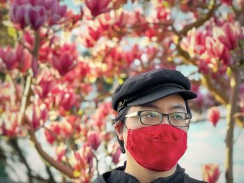 Portrait of woman with red flowers in park