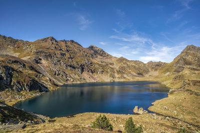 Scenic view of lake and mountains against blue sky