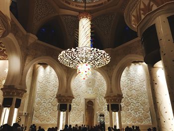 Low angle view of illuminated chandelier hanging in building