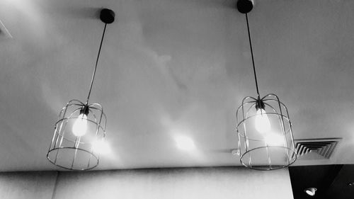 Low angle view of illuminated electric lamp on table