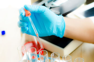 Cropped hand of scientist dripping chemical into test tube