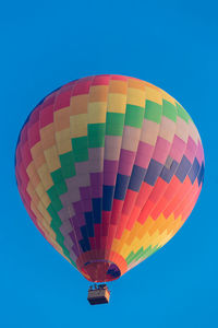 Low angle view of hot air balloons against clear blue sky