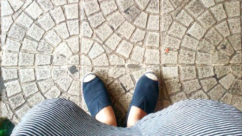 Low section of woman standing on tiled floor