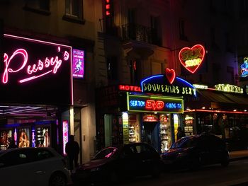 Illuminated sign on street in city at night