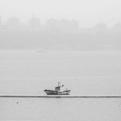 Boat sailing on sea against sky