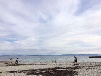 People on beach against sky