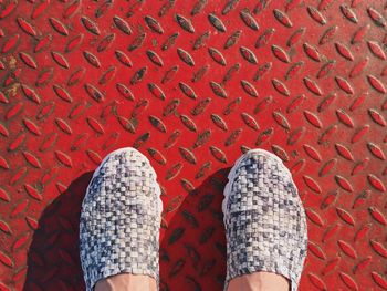 Low section of woman on red diamond plate