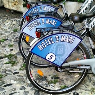 transportation, mode of transport, land vehicle, text, bicycle, communication, stationary, western script, car, parking, information sign, sign, day, street, no people, outdoors, guidance, blue, road sign, wheel