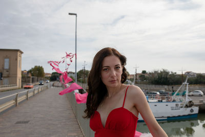 Portrait of woman standing on pier at harbor