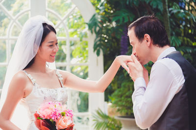 Married couple holding bouquet sitting outdoors