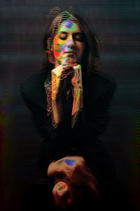 Digital composite image of woman with illuminated hair against black background