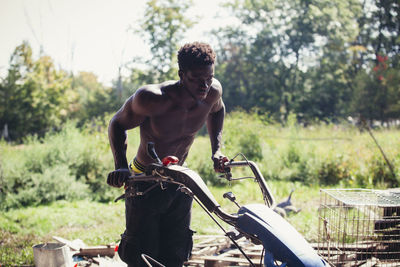 Shirtless young man working at farm