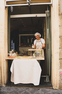 Portrait of young woman standing by food at store