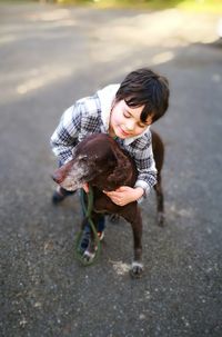 High angle view of boy playing with dog