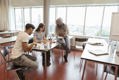 Multi-ethnic students learning together in university classroom