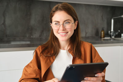 Portrait of young woman using digital tablet