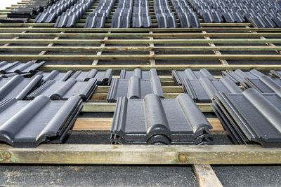 Roof ceramic tile arranged in packets on the roof on roof battens. laying tiles on a boarded roof.